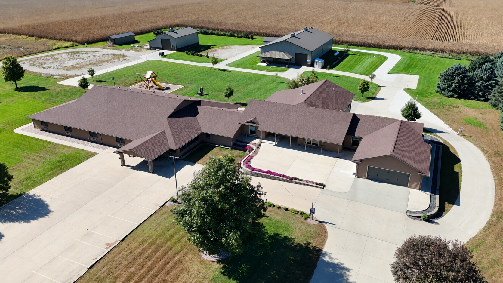 Aerial view of connected campus buildings, driveways, and outbuildings